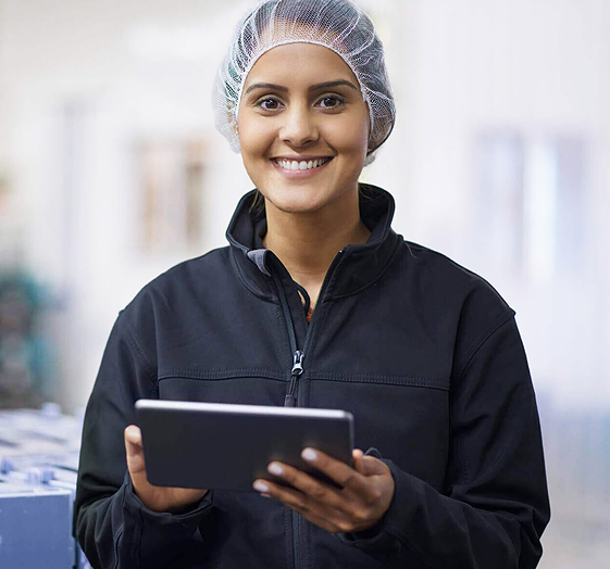 Frau mit Haarnetz und Tablet in den Händen, lächelnd